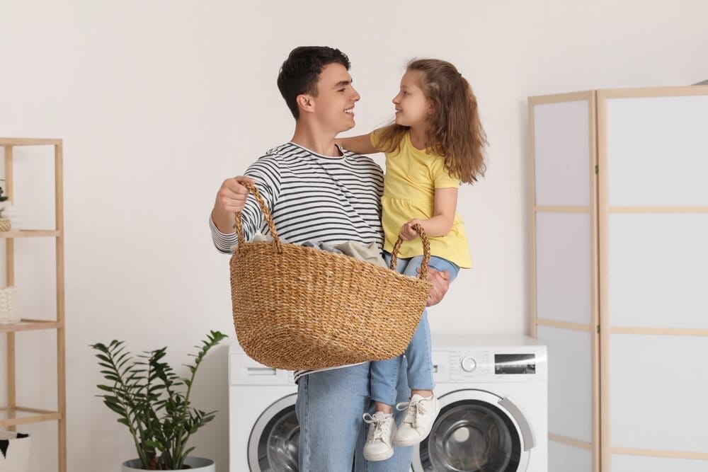 ojciec z córką trzyma koszyk z praniem