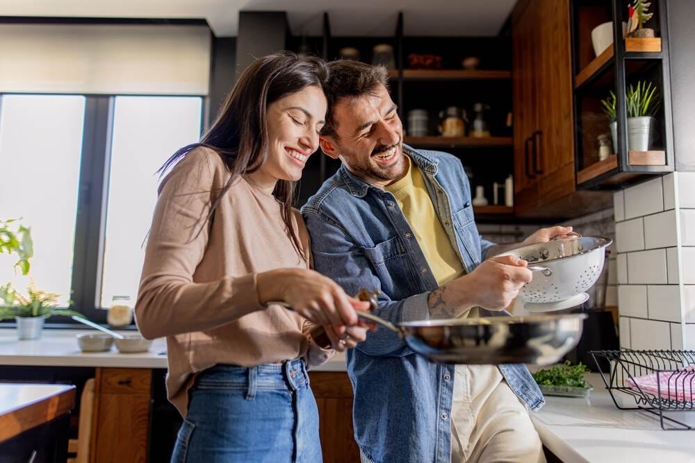 para osób kotouje w kuchni smiejąc się