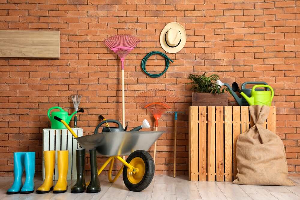zestaw narzędzi ogrodowych ustawionych pod ścianą
