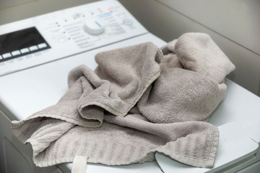 brudny ręcznik rzucony na pralkę