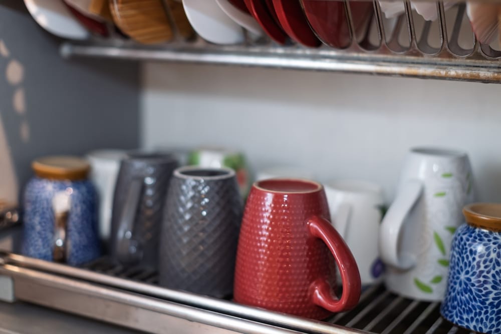 kolorowe kubki na suszarce do naczyń