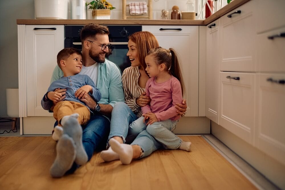 szczęśliwa rodzina siedzi na podłodze w domu